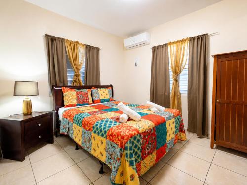 a bedroom with a bed with a colorful blanket at Arenales Guest House in Isabela