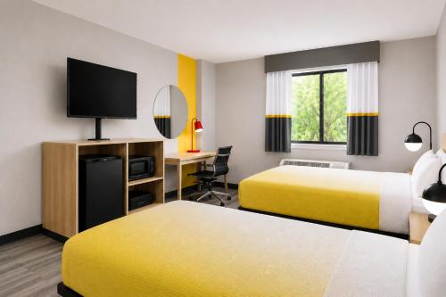 a hotel room with two beds and a desk at Super 8 by Wyndham Champaign in Champaign