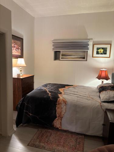 a bedroom with a bed and a table with a lamp at Cozy Home in Flin Flon