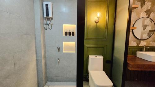 a bathroom with a toilet and a shower and a sink at Dayunan in Bacolod
