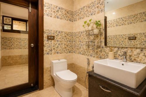 a bathroom with a toilet and a sink at Ramashray - Mud House Living in Haldwāni