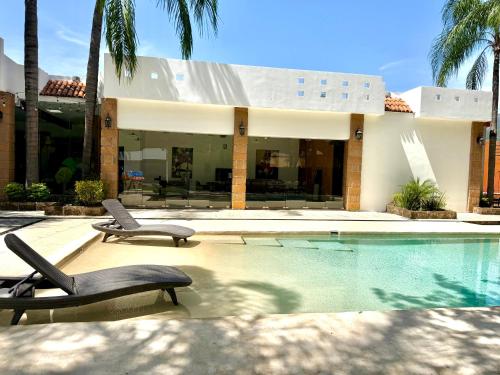 a house with a swimming pool and two lounge chairs at Quinta Encanto in Santiago Nuevo León in Santiago