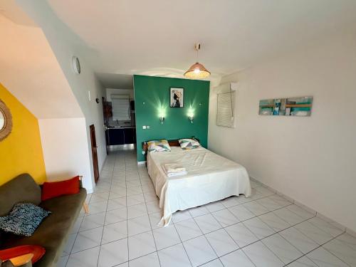 a bedroom with a bed and a green wall at Aqua vista appartement in Le Marin
