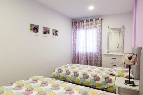 a bedroom with two beds and a dresser and a window at Amazing sea view in Los Cristianos in Los Cristianos