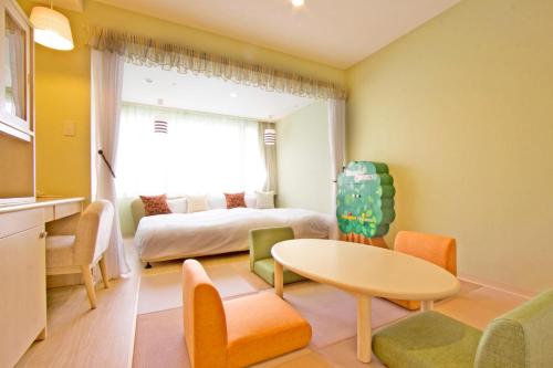 a room with a bed and a table and chairs at Hotel Epinard Nasu in Nasu