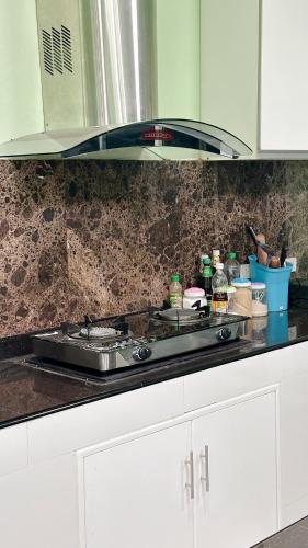 a kitchen counter with a stove top in a kitchen at The Green House Pool Villa Udonthani in Ban Ngoi