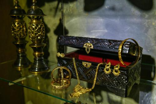 a glass table with gold jewelry and a purse at Ohana House @ 15 Kuli in Melaka