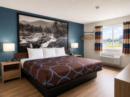 a hotel room with a bed and a window at Super 8 by Wyndham Canandaigua in Canandaigua