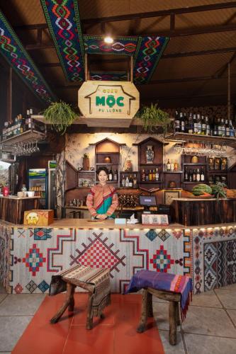 a woman is standing behind a counter in a store at Gateway Inn PuLuong in Pu Luong