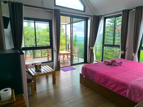 a bedroom with a bed and a large window at Ban Rai Rabeang Mok in Khao Kho