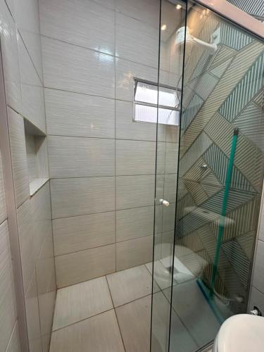 a glass shower in a bathroom with a staircase at Conforto - Casa completa com ar-cond - Wi-Fi in Trindade