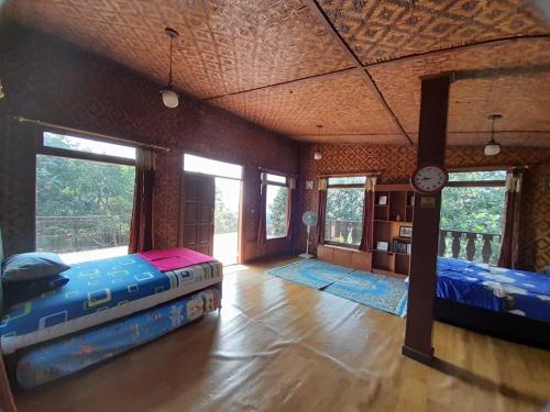 a bedroom with two beds in a room with windows at Salak Sunrise Homestead in Bogor