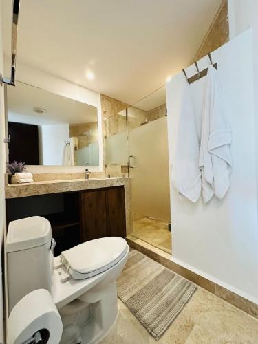 a bathroom with a toilet and a sink at Navela oceanfront apartment in Telchac Puerto