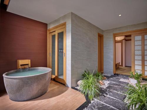 a bath tub sitting in the middle of a courtyard at Kobi Onsen Resort Hue, Affiliated by Meliá in Hue