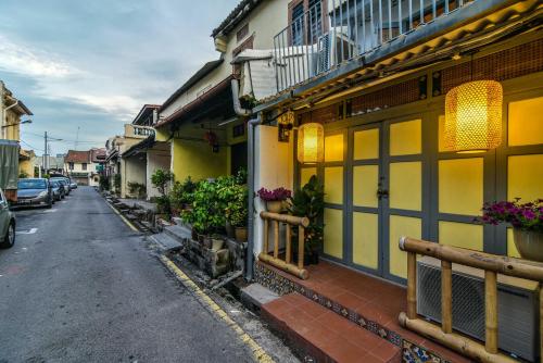 a street with buildings and flowers on the side of the road at Ohana House @ 15 Kuli in Melaka