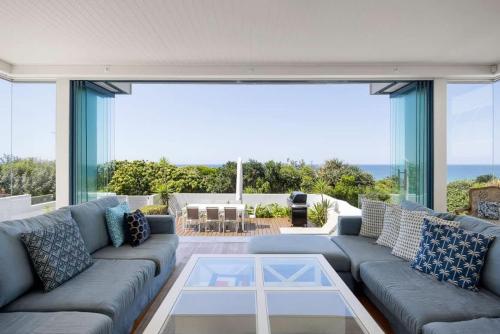 a living room with a couch and a large window at The Beach Shack: Getaway on Sunshine Beach in Noosa Heads