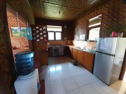 a kitchen with a white refrigerator and a stove at Salak Sunrise Homestead in Bogor