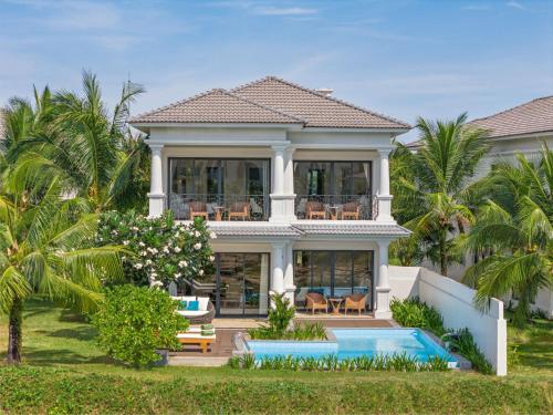 a villa with a swimming pool and a house at Meliá Vinpearl Phu Quoc in Phú Quốc