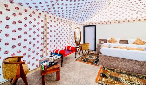 a bedroom with a king sized bed and a chair at Jaisalmer Sand Dunes Resort in Jaisalmer
