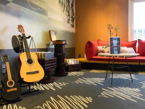 a living room with a guitar and a couch at ibis Aracaju in Aracaju