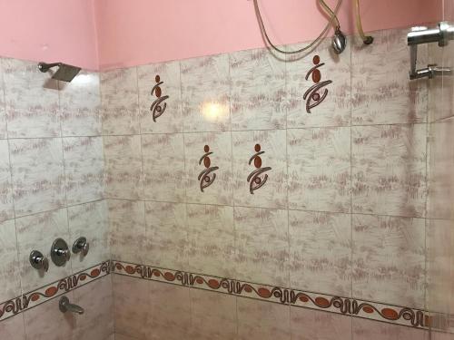 a bathroom with a shower withcriptions on the wall at Hotel D R International in Ambāla