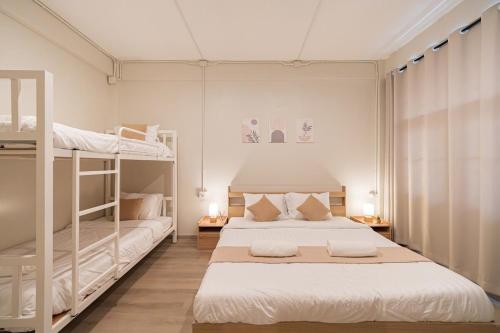 a bedroom with two beds and two bunk beds at Siam Place - Spacious Family House in Bangkok in Bangkok