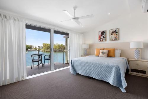 a bedroom with a bed and a view of the water at Driftwood 6 Private Beach Stay in Noosaville