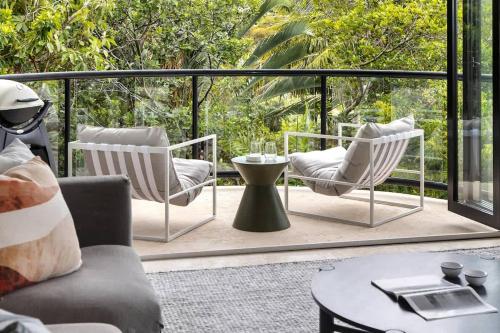 a patio with two chairs and a coffee table at Beach Luxury, Ocean Views & Pool in Noosa Heads