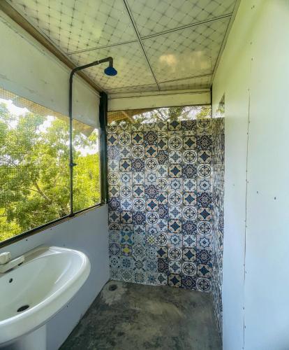 a bathroom with a tub and a sink and a window at Green Tree House Yala in Yala