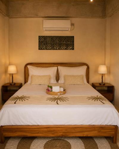 a bedroom with a bed with a tray of flowers on it at Seraya Villas in Kuta Lombok