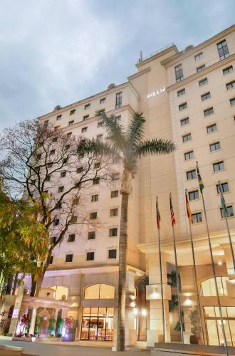 a building with a palm tree in front of it at Meliá Campinas in Campinas