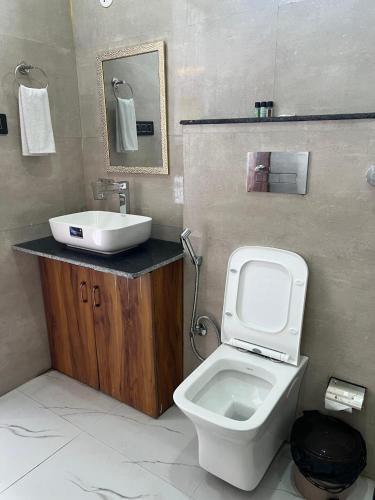 a bathroom with a white toilet and a sink at Hotel Surya Inn in Kānsrao