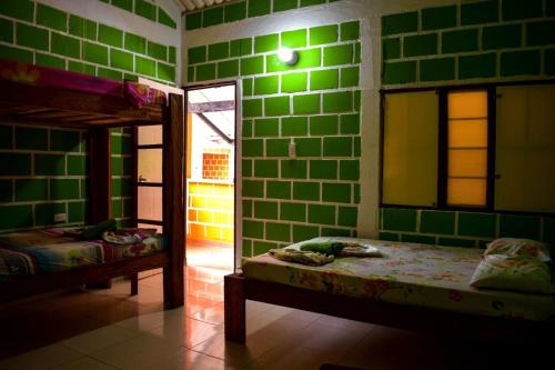 a bedroom with green tiled walls and a bunk bed at hotel con piscina Ladrilleros in Ladrilleros