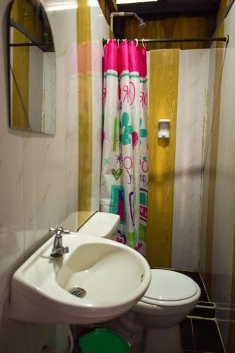 a bathroom with a sink and a toilet and a shower curtain at hotel con piscina Ladrilleros in Ladrilleros