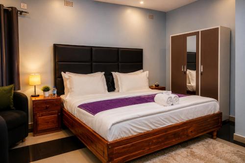 a bedroom with a large bed and a chair at NEBCON Executive Lodge in Kitwe