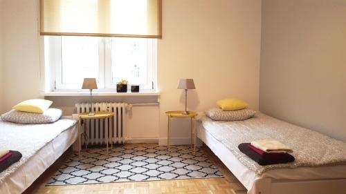 ポズナンにあるApartament Centrum Rynekのベッド2台と窓が備わる小さな客室です。