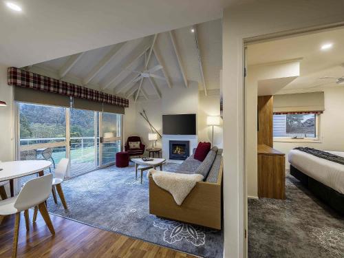 a bedroom with a bed and a living room at The Sebel Pinnacle Valley in Merrijig