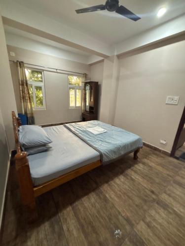 a bedroom with a bed with a ceiling fan at Haven Stay in Panchanai