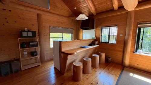 a large room with wooden walls and wooden floors at Karin in Minami Aso