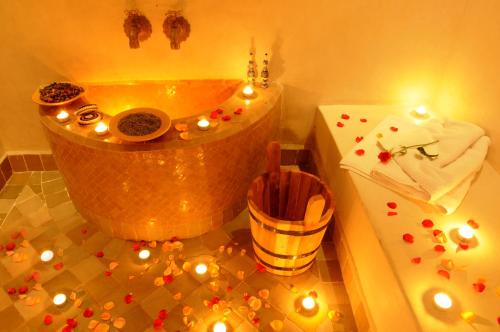 ein Bad mit einer Badewanne mit Kerzen in der Unterkunft Riad Les Hibiscus in Marrakesch