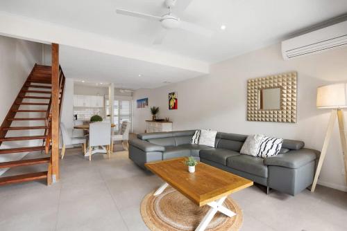 a living room with a couch and a table at Moondarah: Pet-Friendly Escape in Noosa Heads