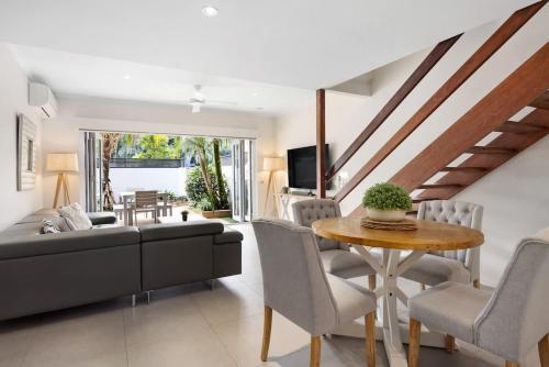 a living room with a couch and a table at Moondarah: Pet-Friendly Escape in Noosa Heads