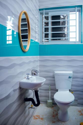 a bathroom with a white toilet and a sink at NEBCON Executive Lodge in Kitwe