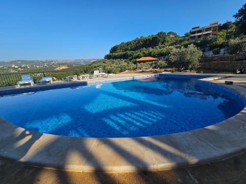 a large swimming pool with blue water at Moufid villa in Al Mīdān