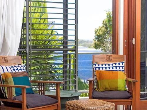 a porch with two chairs and a view of the water at Noosa Dua 2 Balinese Retreat in Noosa Heads
