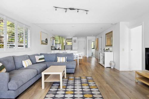 a living room with a blue couch and a table at Noosa Haven Apt 6 Riverside Retreat in Noosaville