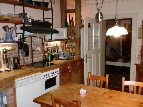 a kitchen with a table and a white stove top oven at Anno-Nostalgia in Rheinsberg
