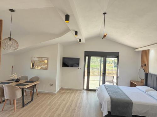 a bedroom with a bed and a table and a dining room at Apartments Lj in Ulcinj
