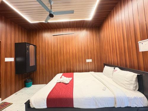 a bedroom with a large bed in a wooden wall at DPD Beach Hotel in Pondicherry