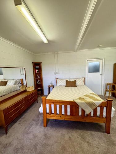 a bedroom with a large bed and a wooden bed frame at Backyard Bliss in Waikerie